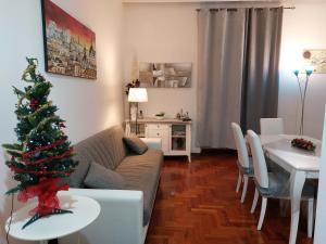 ein Wohnzimmer mit einem Weihnachtsbaum und einem Tisch in der Unterkunft Vespasiano 49 in Rom