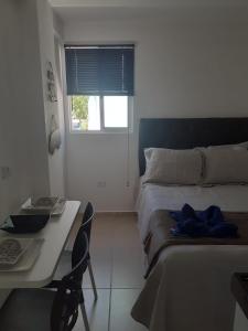 a bedroom with a bed and a table and a desk at Studio Moah 205_Porto de Galinhas in Porto De Galinhas