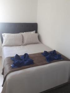 a bed with two blue bows on it at Studio Moah 205_Porto de Galinhas in Porto De Galinhas