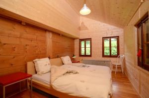 a bedroom with a bed in a room with wooden walls at Spacious Swiss Alpine Chalet for Nature Lovers in Val-d'Illiez