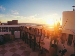 Blick auf den Sonnenuntergang von einem Balkon mit Pflanzen in der Unterkunft Tamraght White Hostel in Tamraght Ouzdar