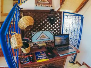 Ein Laptop steht auf einem Tisch neben einer Treppe. in der Unterkunft Tamraght White Hostel in Tamraght Ouzdar
