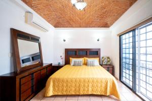 una camera con letto, TV e finestre di PENINSULA STAYS 3 BR House & AC + Private Parking + FAST WIFI a Chetumal