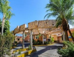 a resort with palm trees and a stone bridge at Motel Primavera in Guadalajara