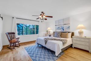 a bedroom with a bed and a chair and a window at Bahama Haven Saltwater Canal Pool Home w dock and boat lift in Palm Coast +43 photos
