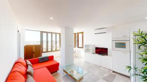 een woonkamer met een rode bank en een glazen tafel bij Las Palmeras - Best Location Cozy Apartment in Fuengirola