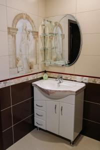 een badkamer met een wastafel en een spiegel bij Котедж «Медовий сад» in Verkhovyna