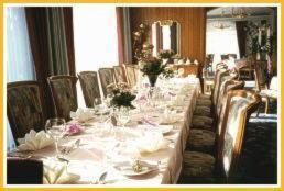 einen langen Tisch in einem Restaurant mit weißen Tischen und Stühlen in der Unterkunft Hotel Krone in Gößweinstein