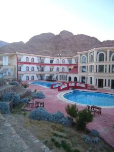 a large building with a swimming pool in front of it at Holy Valley Hotel in Saint Catherine