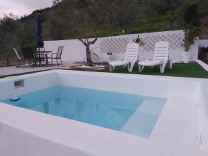 - une piscine blanche avec des chaises et une table dans l'établissement Casa Puerto Blanco II, à Algodonales