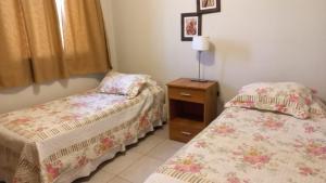 1 dormitorio con 2 camas, mesita de noche y falda en Aires del Parque en Salta