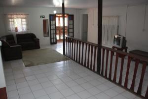 sala de estar con sofá y TV en Pousada Al Chaddai, en São Lourenço