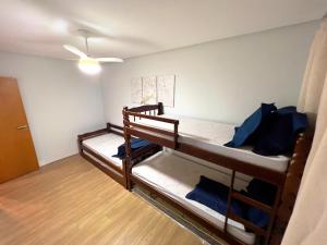 um quarto com 2 beliches com almofadas azuis em Apartamento 82 - Guilhermina na Praia Grande