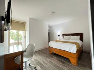 a bedroom with a bed and a desk and a desk at Neo Business Hotel in Culiacán