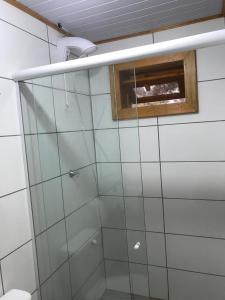 a bathroom with a glass shower with a window at Cabana da Colina 2 in Bom Jardim da Serra