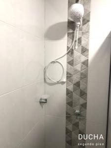 a shower with a shower head in a bathroom at Hostal Diana in San Agustín