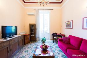 sala de estar con sofá rojo y TV en A Casa di Anna - Apartment, en Palermo