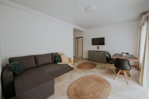 uma sala de estar com um sofá e uma mesa em THE NOOK APARTHOTEL em Timişoara