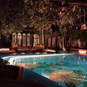 a swimming pool at night with an umbrella at Lahabana Huahin by Moji in Hua Hin