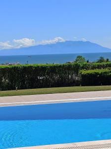 a blue swimming pool with the ocean in the background at Villa Belvedere in Alexandroupoli
