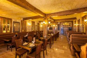 Un restaurante con mesas y sillas en una habitación. en Kayakapi Premium Caves Cappadocia, en Ürgüp