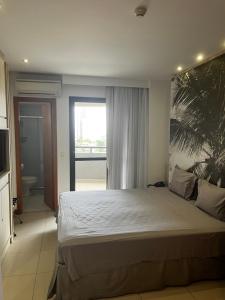 una camera da letto con un letto grande e una grande finestra di Studio particular em Hotel a Salvador