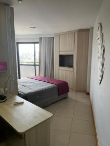 um quarto de hotel com uma cama e uma televisão em Studio particular em Hotel em Salvador