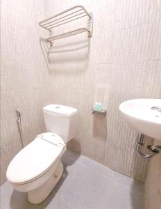 a bathroom with a white toilet and a sink at Front One Green Boutique Hotel Abepura in Abepura +20 photos