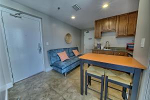 a kitchen and living room with a blue couch at PierPark Cozy Condo w View Sterling Breeze Resorts in Panama City Beach