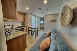 a living room with a couch and a kitchen at PierPark Cozy Condo w View Sterling Breeze Resorts in Panama City Beach