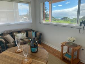 a living room with a table with two wine glasses at Paradise on Jones Beach Kiama - Beachfront unit with direct beach access & views in Kiama Downs