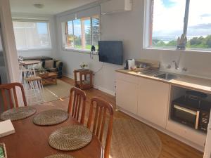 a kitchen and living room with a table and chairs at Paradise on Jones Beach Kiama - Beachfront unit with direct beach access & views in Kiama Downs