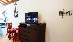 telewizor na komodzie w pokoju w obiekcie Toca dos Coelhos Chalés w mieście Carrancas