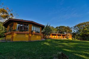 a house on a grassy field with a building at Sunset Monteverde in Monteverde Costa Rica