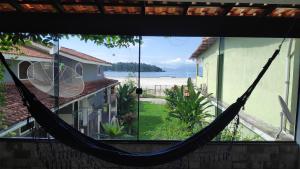 a hammock in a house with a view of the beach at Flat com portão na Praia in Angra dos Reis