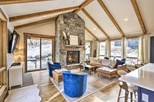 an open living room with a stone fireplace at Luxe Home with Patio and Pool Access in Silverthorne! in Silverthorne