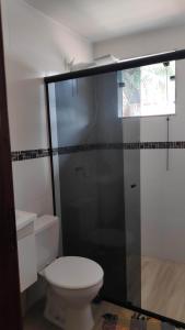ein Badezimmer mit Toilette und Glasdusche in der Unterkunft Flat com portão na Praia in Angra dos Reis