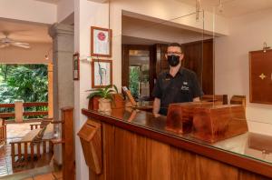 a man wearing a mask standing behind a counter at Capitán Suizo Beachfront Boutique Hotel in Tamarindo