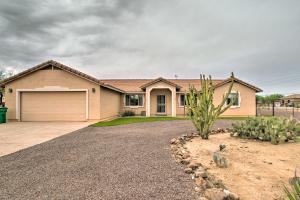 a house with a cactus in front of a driveway at Phoenix Kick Back Corral with Outdoor Oasis! in Anthem