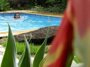 una mujer está nadando en una piscina en Pousada Fazenda São Luiz en São Luiz do Paraitinga