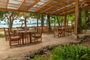 un restaurante con mesas y sillas en la playa en Capitán Suizo Beachfront Boutique Hotel, en Tamarindo