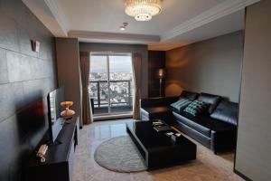 a living room with a black leather couch and a television at HOTEL STATE TENNOJI in Osaka