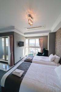 a hotel room with two large beds and a chandelier at HOTEL STATE TENNOJI in Osaka