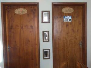 two wooden doors in a room next to each other at Pousada Santa Mônica in Divinópolis