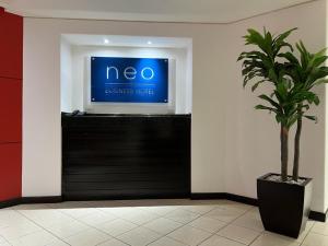 Neo Business Hotel في كولياكان: زرع في غرفة مع علامة على الجدار