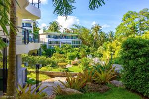 una casa con un giardino davanti di KARON BUTTERFLY KATA HILL CONDO By THE SEA a Ban Karon