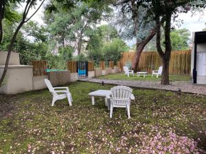 twee witte stoelen en een tafel in een tuin bij La Escondida Salta 5 in Salta