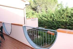 einen Balkon mit Metallgeländer und Bäumen in der Unterkunft Appartamento Greta in Porto Azzurro