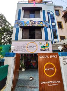 un edificio con una señal de que el árbol de readslost convierte el espacio social en HOSHTEL99 - Stay, Cowork and Cafe - A Backpackers Hostel, en Pune