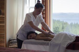 una mujer está ayudando a una mujer en una cama en Das Dorf Hotel, en Pucón